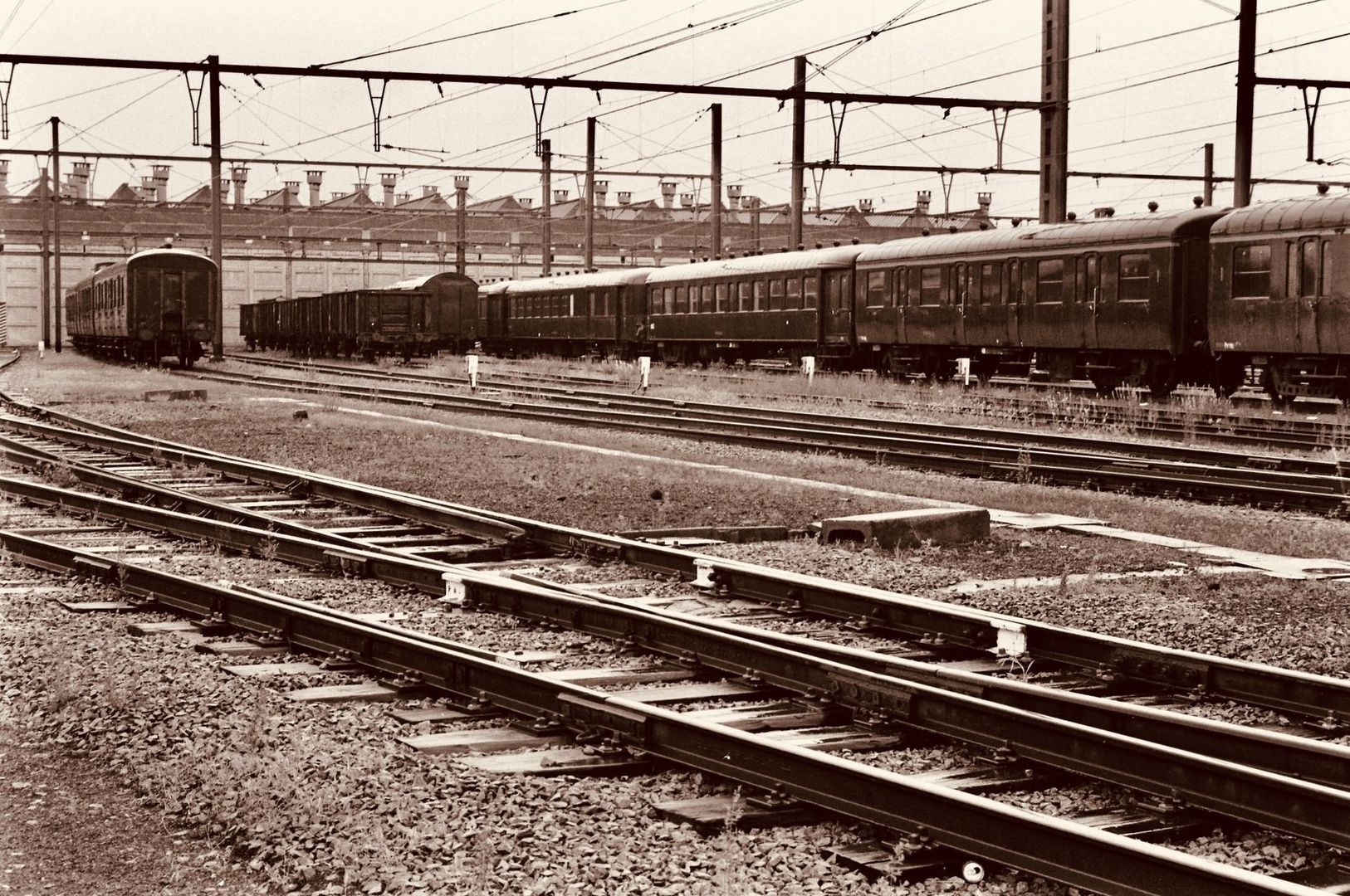 Historischer Eisenbahnhof mit Personenwagen, Güterwagen und weitläufigen Gleisanlagen